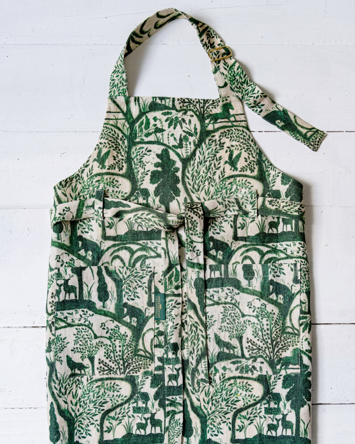 Mind-the-gap-enchanted-woodland-linen-printed-wallpaper-scene-apron-stonewashed-wolves-birds-trees-woodland-forest-green-on-cream