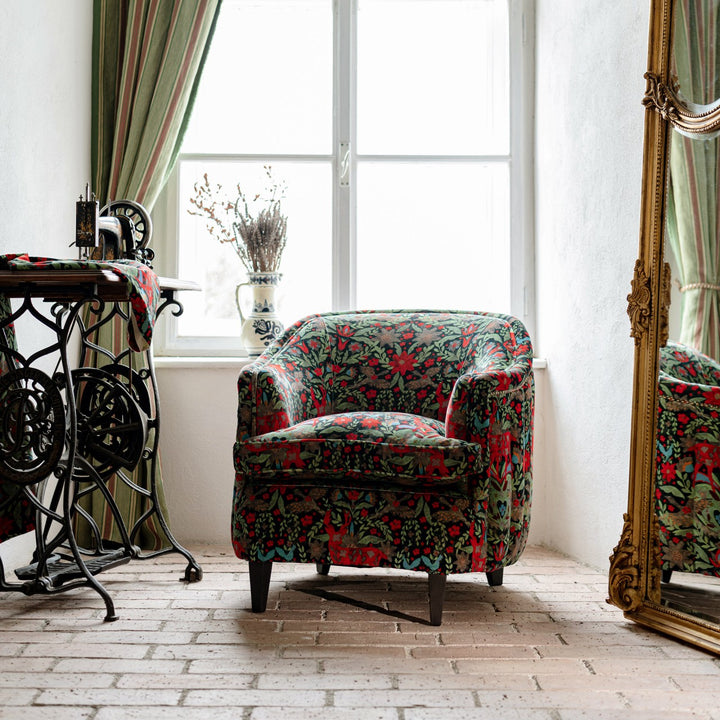 Mind-the-gap-scarlett-chair-der-koning-velvet-tub-chair-leather-studs-wooden-legs-crimson-red-stags-floral-black-plush-background-statement-chair-alpine-vibes-cabin-furniture